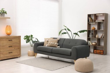 Rahat kanepesi ve ahşap raf ünitesi olan şık bir oturma odası. İç tasarım