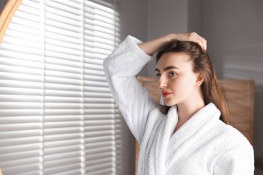 Evde sağlıklı saç kökleri olan güzel bir kadın. Metin için boşluk