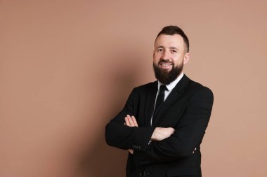 Kahverengi arka planda takım elbiseli yakışıklı sakallı adam. Metin için boşluk