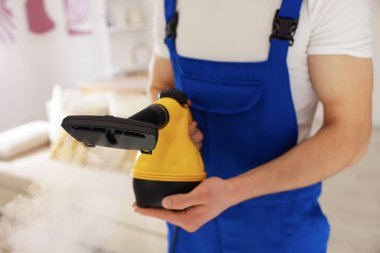 Evde buhar temizleyicisi olan kapıcı, yakın çekim.