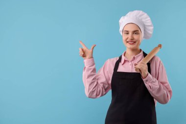 Açık mavi arkaplandaki bir şeyi işaret eden yuvarlak iğneli şekerleme, metin için boşluk