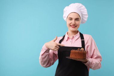 Açık mavi arkaplanda çikolatalı kek, mesaj için yer var.