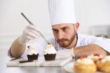 Şekerci, mutfakta çikolata traşlı lezzetli kekler yapıyor.