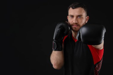 Siyah arka planda dövüşen boks eldivenli adam, metin için boşluk