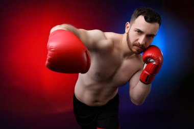 Boks eldivenli bir adam neon ışıklarıyla arka planda savaşıyor.