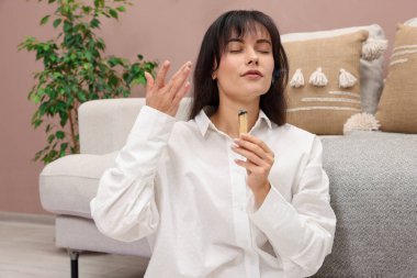 Yanan Palo Santo 'su olan kadın evde takılıyor.