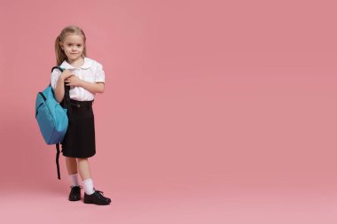 Pembe arka planda sırt çantası olan liseli kız. Metin için boşluk