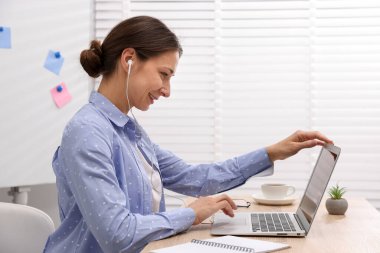 Gülümseyen çevrimiçi hoparlör masadaki dizüstü bilgisayarla internetten yayın yapıyor.