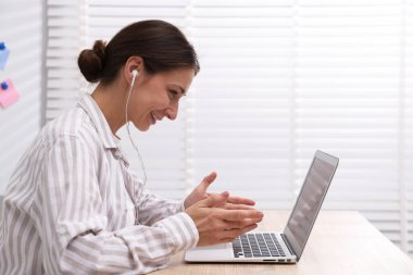 Gülümseyen çevrimiçi hoparlör masadaki dizüstü bilgisayarla internetten yayın yapıyor.