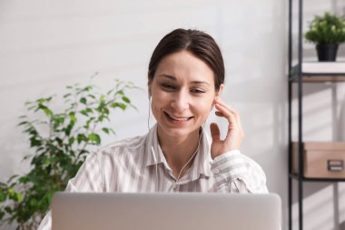 Gülümseyen çevrimiçi hoparlör içeride dizüstü bilgisayarla webinar yayınlıyor