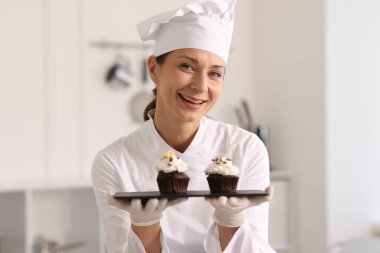 Mutfakta lezzetli kekleri olan mutlu pastacı.