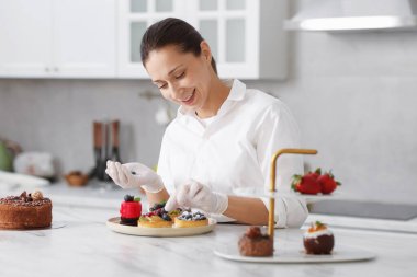 Sofrada yaban mersinli tart süsleyen şekerci.