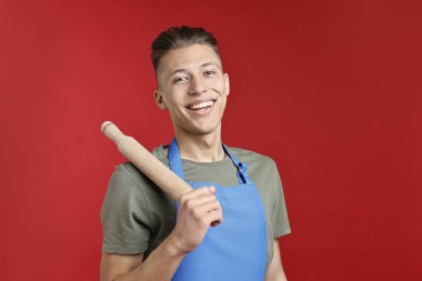 Kırmızı arka planda merdanesi olan mutlu adam