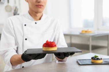 Mutfaktaki gri masada lezzetli tartlı pastacı, yakın plan.