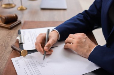 Ofisteki ahşap masada noter imzalı belge, yakın plan.