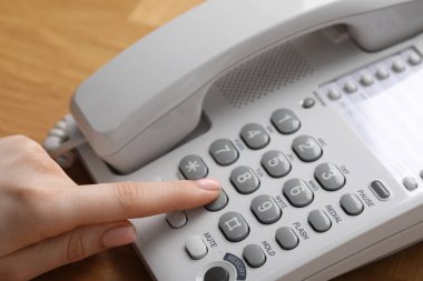 Ahşap masada telefonla arayan kadın, yakın plan.