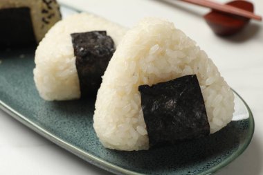 Pirinç topları (onigiri) ışık masasında, yakın plan. Geleneksel Japon yemeği