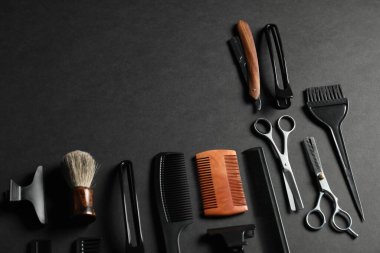 Siyah masanın üzerinde birçok farklı berber aletleri var. Metin için boşluk