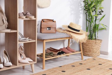 Farklı şık ayakkabılar, hasır şapkalar, poşetler ve ev bitkileriyle ayakta duruyor.