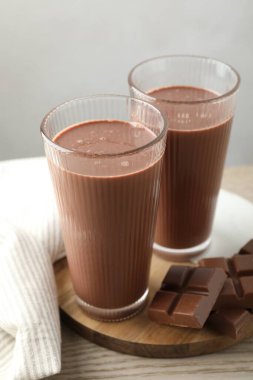 Lezzetli çikolatalı süt ve çubuklar ahşap masada.