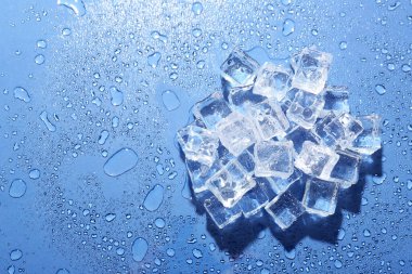 Eriyen buz yığınları ve mavi arka planda su damlaları, üst manzara. Metin için boşluk