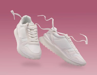 Pembe arka planda havadaki şık spor ayakkabılar