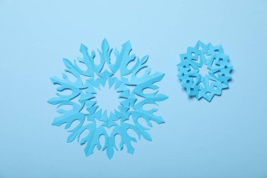 Açık mavi zemin üzerinde güzel kar taneleri, düz uzanmış.