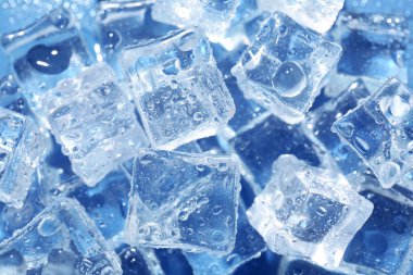 Eriyen buz küpleri ve su damlaları mavi arkaplanda, görünümün üzerinde