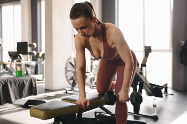 Spor salonunda, halterli kadın antrenmanı.