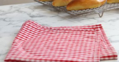 Beyaz mermer masaya fırında köfteli tabak koyan kadın, yakın plan.