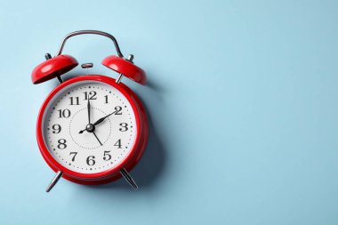 Açık mavi arka planda kırmızı alarm saati, üst manzara. Metin için boşluk