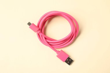 Bej arka planda bir USB şarj kablosu, üst görünüm