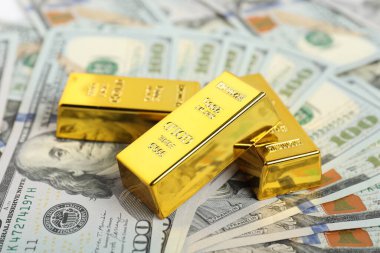 Parlak altın külçeler dolar banknotları, yakın plan