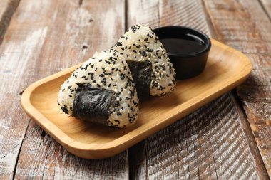 Pirinç topları (onigiri) ve soya sosu ahşap masada, yakın plan. Geleneksel Japon yemeği