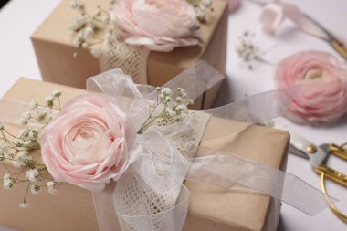 Çiçekçi. Beyaz arkaplanda kutular, çiçekler, kurdele ve makas, yakın plan