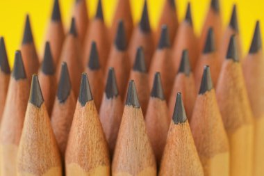 Sarı arkaplanda birçok grafit kalem, yakın plan