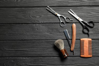 Siyah ahşap masa üzerinde birçok farklı berber aletleri, düz yatıyordu. Metin için boşluk