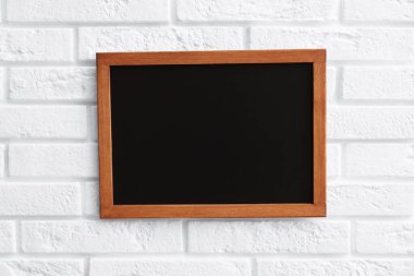 Beyaz tuğla duvarda boş bir karatahta