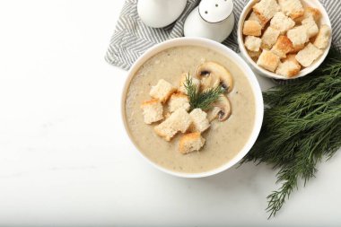 Beyaz masada servis edilen kızarmış ekmek ve dereotlu kremalı leziz mantar çorbası. Metin için boşluk