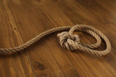 Ahşap arka planda düğümlü pamuk ip, yakın plan