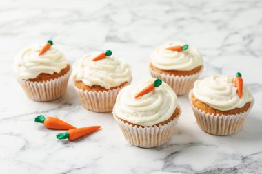 Lezzetli havuçlu kekler beyaz mermer masada, yakın plan.