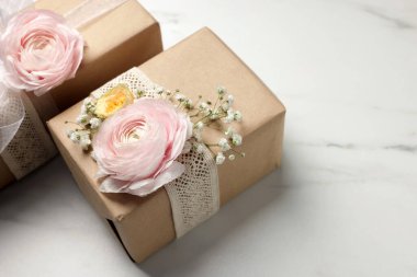 Çiçekçi. Üzerinde çiçekler ve kurdele olan kutular beyaz mermer masa, yakın plan. Metin için boşluk