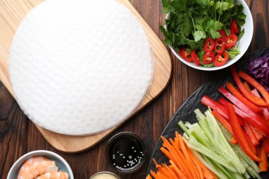 Yenebilir pirinç kağıtları ve malzemeler ahşap masada, düz yerde.