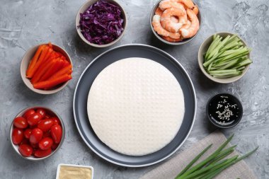 Pirinç kağıt çarşaflar ve açık gri masa üzerindeki farklı malzemeler, düz uzanmış.