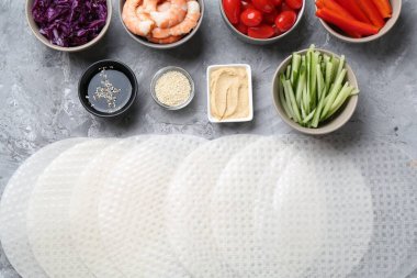 Pirinç kağıt çarşaflar ve açık gri masa üzerindeki farklı malzemeler, düz uzanmış.