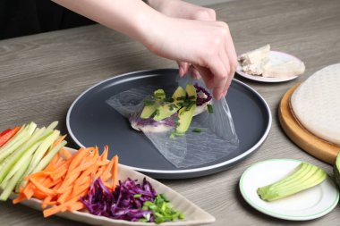 Gri ahşap masada nefis börek yapan kadın, yakın plan.