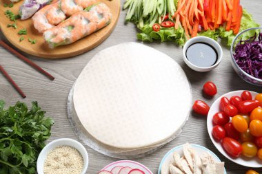 Pirinç kağıt çarşaflar ve gri ahşap masa üzerindeki farklı malzemeler.