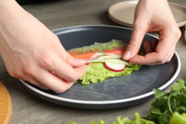 Gri ahşap masada nefis börek yapan kadın, yakın plan.