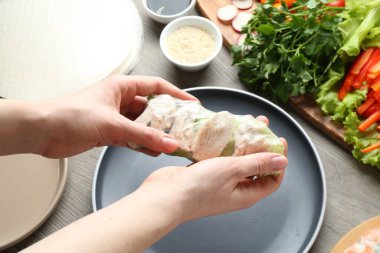 Gri ahşap masada nefis börek yapan kadın, yakın plan.