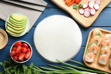 Pirinç kağıt çarşaflar ve mavi ahşap masa üzerindeki farklı malzemeler.